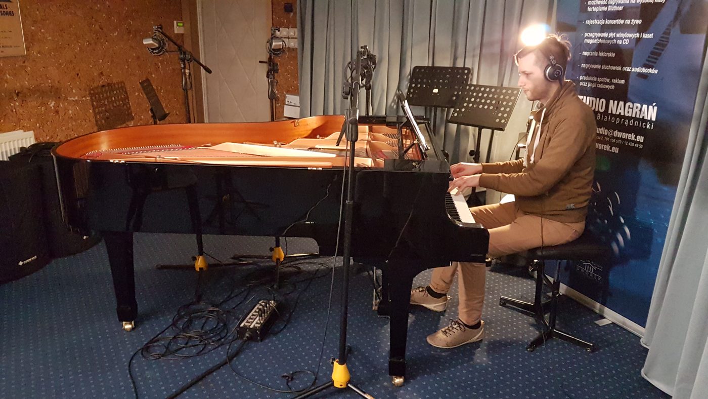 Michał Drezner gra na fortepianie w studiu nagrań